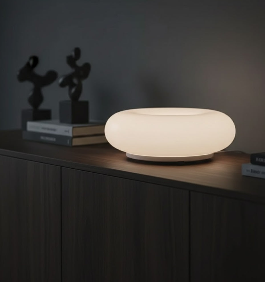 Modern table lamp on a dark wooden surface with a dark background