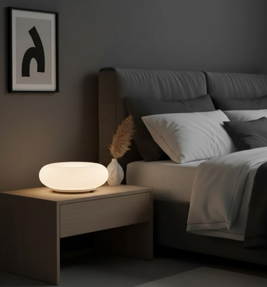 Modern bedroom with a nightstand lamp, bed, and wall art