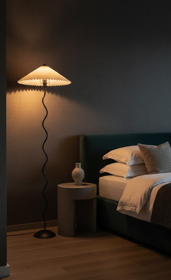 Dark bedroom with a floor lamp, nightstand, and bed