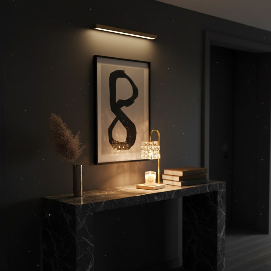 Modern interior with a dark marble console table, decorative items, and a framed abstract artwork on a dark wall